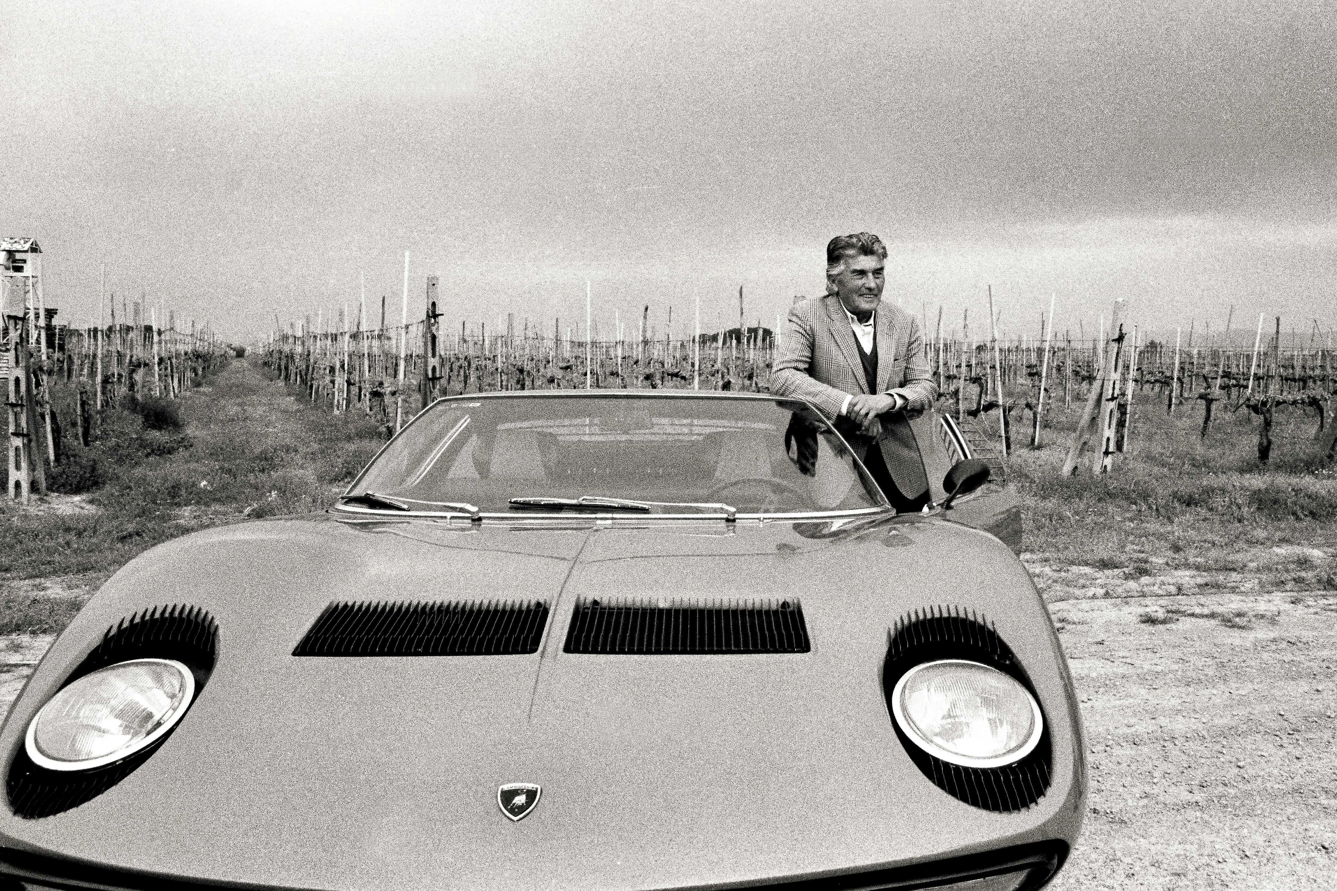 Ferruccio Lamborghini appoggiato alla Miura davanti a dei suoi campi coltivati