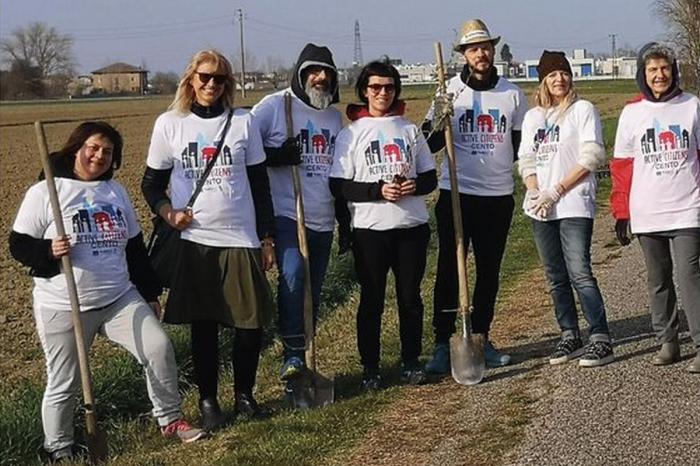 volontari con maglietta di Active Citizens che piantumano le aree verdi 
