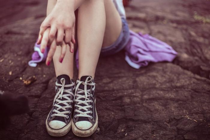 Ragazza seduta con gambe incrociate