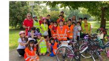 fotografia degli alunni e vigili in giardino con le biciclette
