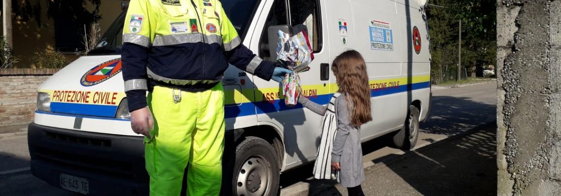 Signore della protezione civile dona uovo di pasqua a bambina