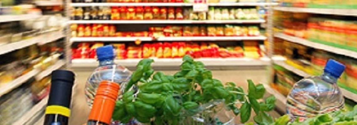 carrello spesa ricolmo tra gli scaffali del supermercato 
